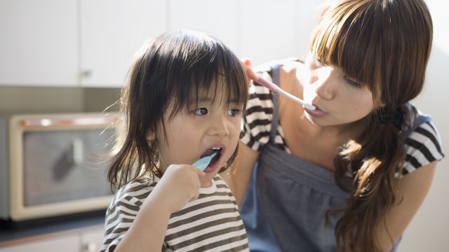 Toddler and mom brushing teeth