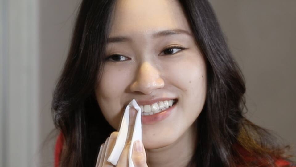 Lady drying her teeth with tissue Lady drying her teeth with tissue