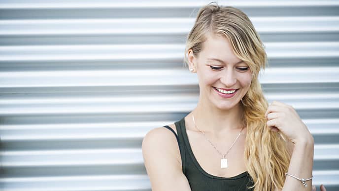 a girl is smiling confidently with white ceramic braces